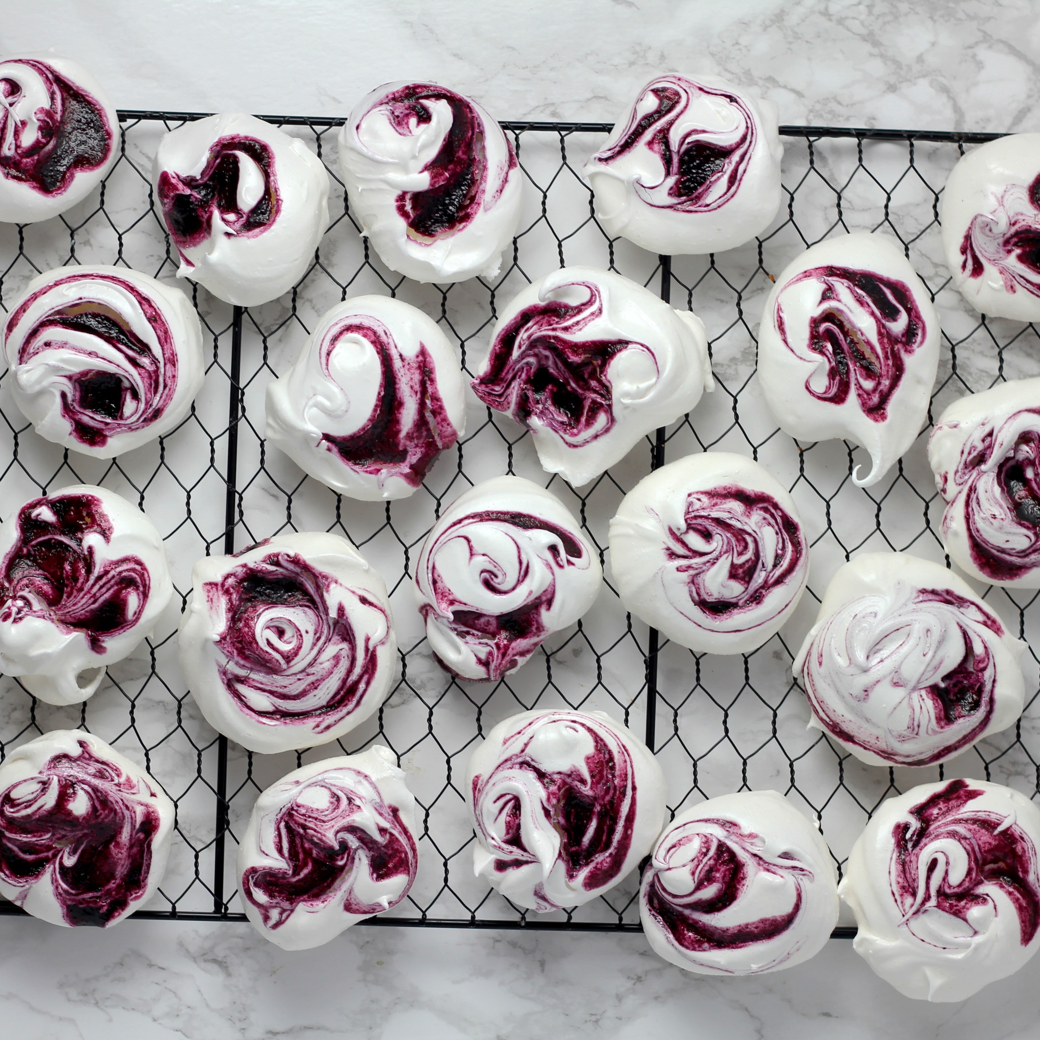 blackcurrant swirled meringues on a wire rack